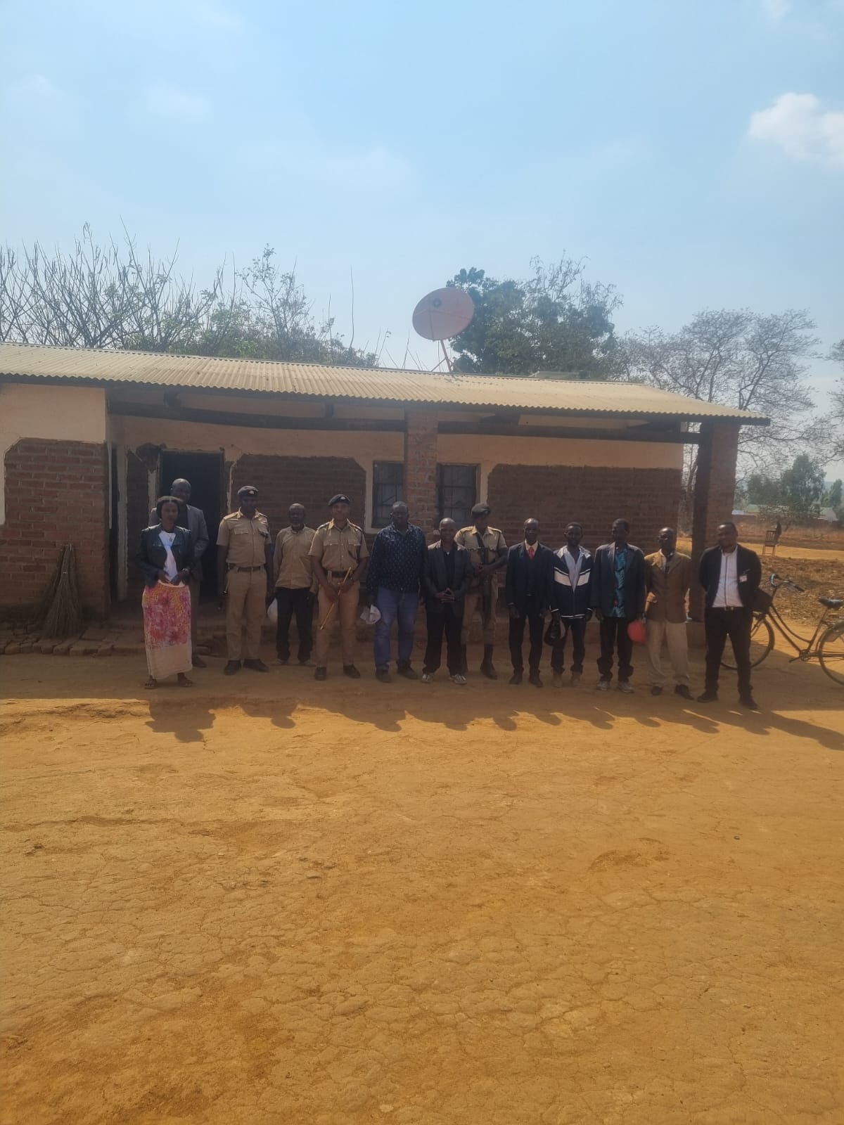 Learners and community members outside a local building
